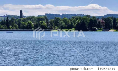 Experience the breathtaking scenic view of a stunning lake featuring a sailboat and a tower Experience the breathtaking scenic view of a stunning lake featuring a sailboat and a tower 139624845