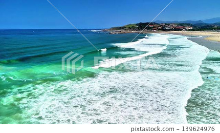 A breathtaking aerial view depicting the stunning blue waves crashing gently upon a sandy beach A breathtaking aerial view depicting the stunning blue waves crashing gently upon a sandy beach 139624976