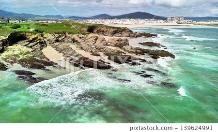 A stunning coastal landscape with waves crashing against rocks in a beautiful scenic view 139624991
