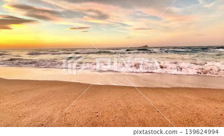 A Serene and Beautiful Sunset Over the Gentle Ocean Waves at the Tranquil Beach Setting A Serene and Beautiful Sunset Over the Gentle Ocean Waves at the Tranquil Beach Setting 139624994