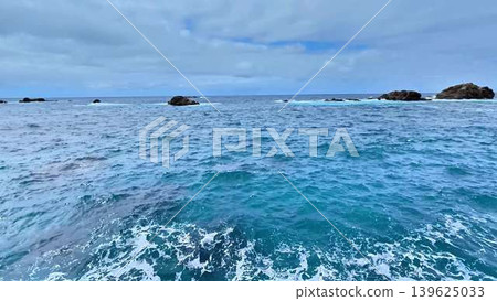 A Serene and Beautiful Coastal View Featuring Azure Waters and Dramatic Rock Formations 139625033