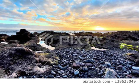 Enjoy the scenic view of a vibrant sunset at the rocky shoreline with its amazing tide pools Enjoy the scenic view of a vibrant sunset at the rocky shoreline with its amazing tide pools 139625049