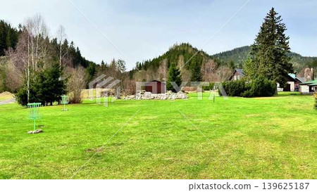 A Serene Green Landscape Featuring Beautiful Hills, Cozy Cabins, and Peaceful Nature A Serene Green Landscape Featuring Beautiful Hills, Cozy Cabins, and Peaceful Nature 139625187