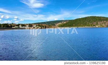 A beautifully serene lake surrounded by stunning landscapes under a clear blue sky 139625190
