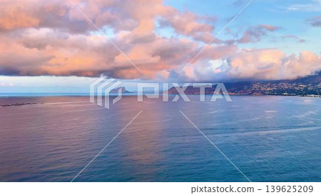 A Stunning, Breathtaking Ocean Sunset with Colorful Clouds Over Completely Calm Waters A Stunning, Breathtaking Ocean Sunset with Colorful Clouds Over Completely Calm Waters 139625209