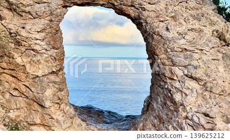 Captivating Scenic Coastal View Through a Beautiful Natural Rock Arch by the Ocean Captivating Scenic Coastal View Through a Beautiful Natural Rock Arch by the Ocean 139625212