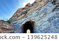 A Tunnel Located within a Rocky Landscape, Gradually Revealing Light at the End of It 139625248
