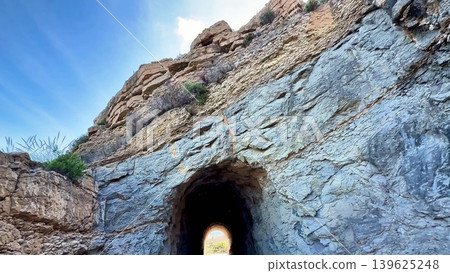 A Tunnel Located within a Rocky Landscape, Gradually Revealing Light at the End of It A Tunnel Located within a Rocky Landscape, Gradually Revealing Light at the End of It 139625248