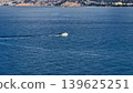 A scenic view of a boat on calm waters next to a coastal landscape, ideal for adventurers 139625251
