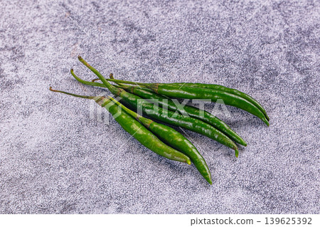 Fresh spicy green chili peppers on a rustic wood tabletop. Fresh spicy green chili peppers on a rustic wood tabletop. 139625392