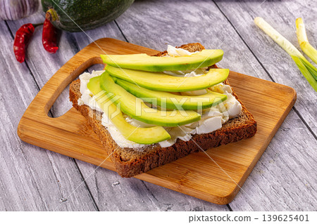 Avocado toast with cream cheese on rye bread with fresh ingredients 139625401