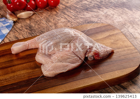 Raw Duck Leg Quarter on Wooden Board with Fresh Tomatoes and Garlic Raw Duck Leg Quarter on Wooden Board with Fresh Tomatoes and Garlic 139625413