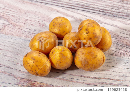 Fresh raw organic yellow potatoes on light rustic wooden background 139625438
