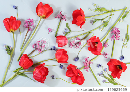 Still life with spring tulips, muscari, hyacinths, forgetmenots and bird cherry against an elegant background. Abstract floral composition and banner for the screen. A floral holiday card Still life with spring tulips, muscari, hyacinths, forgetmenots and bird cherry against an elegant background. Abstract floral composition and banner for the screen. A floral holiday card 139625669