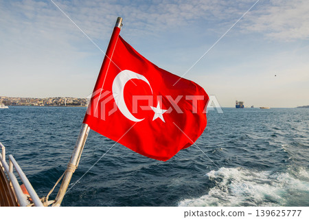 Turkish flag flies on ferry against backdrop of Bosphorus strait. Turkish flag flies on ferry against backdrop of Bosphorus strait. 139625777