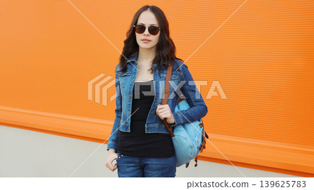 Young woman with backpack , modern teenage girl posing on city street 139625783