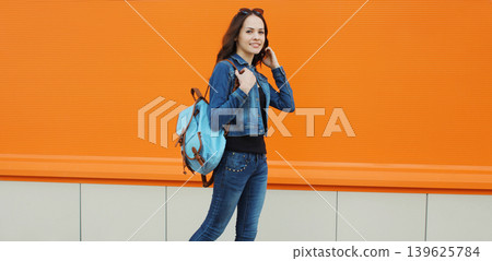 Young woman student smiling with backpack walking in the city 139625784
