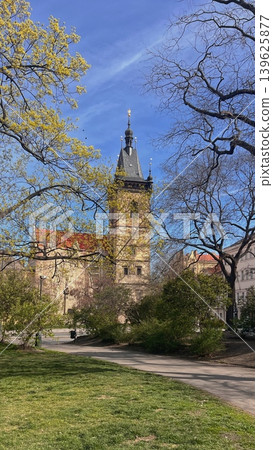 Historic clock tower surrounded by trees and green grass in a park Historic clock tower surrounded by trees and green grass in a park 139625877