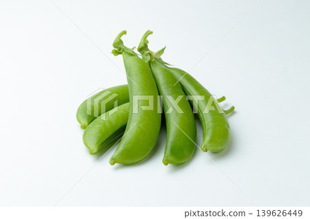 A photograph of five snap peas arranged in a three-dimensional way against a white background. A photograph of five snap peas arranged in a three-dimensional way against a white background. 139626449