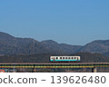 A KiHa 32 series diesel railcar crosses a railway bridge with the majestic Shikoku Mountains in the background. (Photographed on February 21, 2026) 139626480