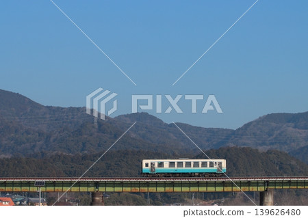 A KiHa 32 series diesel railcar crosses a railway bridge with the majestic Shikoku Mountains in the background. (Photographed on February 21, 2026) A KiHa 32 series diesel railcar crosses a railway bridge with the majestic Shikoku Mountains in the background. (Photographed on February 21, 2026) 139626480