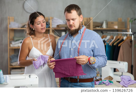 Male tailor discussing textile with girl Male tailor discussing textile with girl 139626726