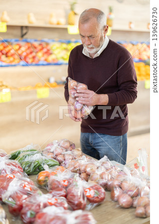 Pensioner in a supermarket is standing in the department with vegetables Pensioner in a supermarket is standing in the department with vegetables 139626730