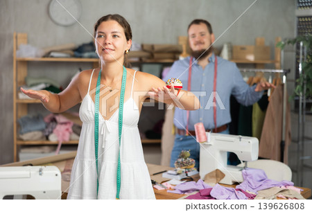 Two young seamstresses doing exercises during break 139626808
