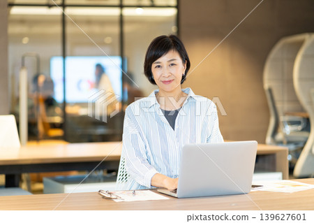 一位中年婦女正在ShareOffice使用電腦。 一位中年婦女正在ShareOffice使用電腦。 139627601