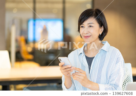 操作智能手機的資深婦女 操作智能手機的資深婦女 139627608