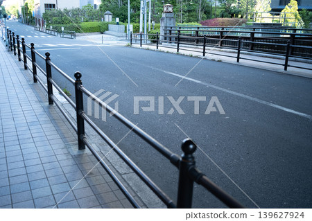 Black iron fences and deserted city sidewalks: A quiet street scene in Tokyo. Black iron fences and deserted city sidewalks: A quiet street scene in Tokyo. 139627924
