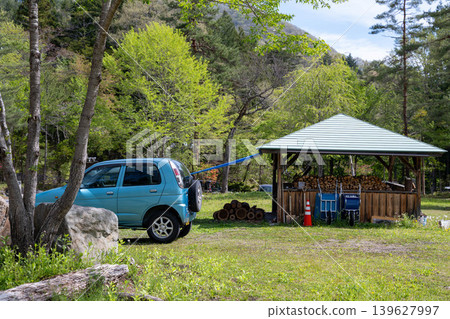 A blue car parked in the lodge at the campsite 139627997