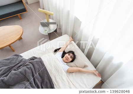 A woman stretching in bed A woman stretching in bed 139628046