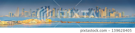 Doha, Qatar- Jan 14 2024, Panoramic  view of the Mina District, part of the port of Doha and long pier, with skyscrapers and buildings in the background, at daytime, Doha, Qatar 139628405