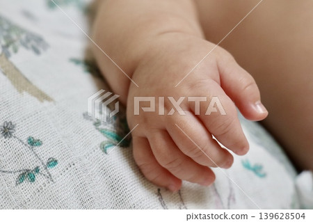 A close-up of a baby's right hand, naturally relaxed | Image for parenting advertisements, baby products, and a sense of security. A close-up of a baby's right hand, naturally relaxed | Image for parenting advertisements, baby products, and a sense of security. 139628504