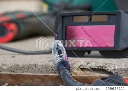 Welding equipment including a protective mask and torch on a rough surface Welding equipment including a protective mask and torch on a rough surface 139628621