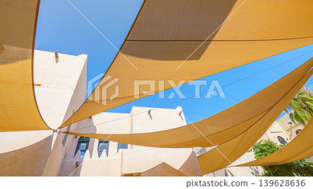 Doha, Qatar- Jan 14 2024, 4k, Bottom-up view of several triangular fabric awnings connected to a pillar in the center, covering the street from sun, Katara cultural village, at daytime, Doha, Qatar Doha, Qatar- Jan 14 2024, 4k, Bottom-up view of several triangular fabric awnings connected to a pillar in the center, covering the street from sun, Katara cultural village, at daytime, Doha, Qatar 139628636