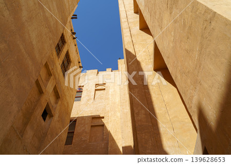 Doha, Qatar - Jan 14 2024, Bottom-up view of the narrow courtyard of the well, the blue sky is visible on top, in Souq Waqif area, at daytime, Doha, Qatar 139628653