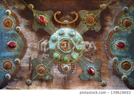 Close-up view of the bronze decoration element with floral pattern of an antique chest with inlaid crystals, Doha, Qatar Close-up view of the bronze decoration element with floral pattern of an antique chest with inlaid crystals, Doha, Qatar 139628683