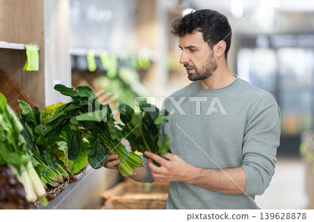 Adult woman choosing spinach at vegetable market Adult woman choosing spinach at vegetable market 139628878