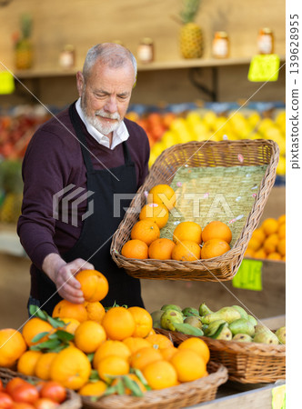 Supermarket senior worker checking fruit quality Supermarket senior worker checking fruit quality 139628955