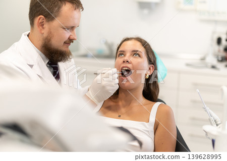 Male dentist checking the teeth of a woman in the office Male dentist checking the teeth of a woman in the office 139628995