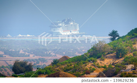 Sir Bani Yas Island, United Arab Emirates - Jan 18 2024, aerial panoramic view of tree-covered mountain, in background, the MSC Virtuosa cruise ship is moored near the beach, Sir Bani Yas Island, UAE Sir Bani Yas Island, United Arab Emirates - Jan 18 2024, aerial panoramic view of tree-covered mountain, in background, the MSC Virtuosa cruise ship is moored near the beach, Sir Bani Yas Island, UAE 139629236