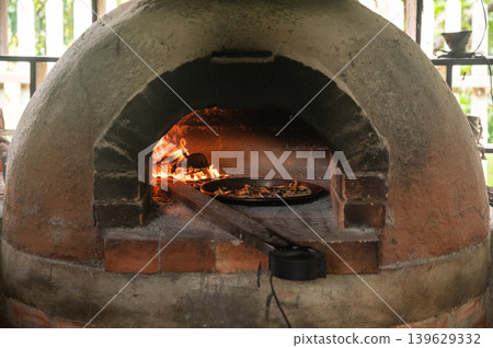 A pizza baking in wood fired oven. It can also be used to dry and smoke food. Cooking on a wood fire is authentic and brings an unrivalled flavour to your dishes. A pizza baking in wood fired oven. It can also be used to dry and smoke food. Cooking on a wood fire is authentic and brings an unrivalled flavour to your dishes. 139629332