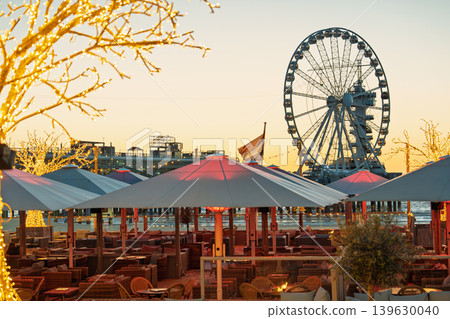 Scheveningen beach resort at sunset, Netherlands. Ferris wheel and outdoor seating area Scheveningen beach resort at sunset, Netherlands. Ferris wheel and outdoor seating area 139630040