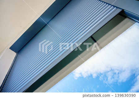 Exterior roller shutter partially open on modern window 139630390