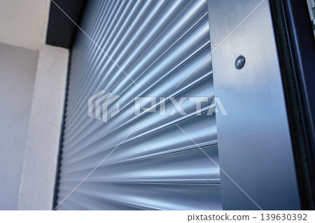 Modern window with roller shutter closing on house exterior 139630392