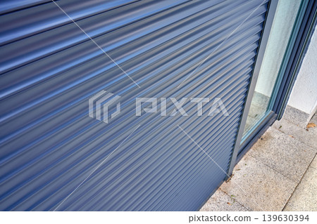 Closed roller shutter on glass door outside modern home Closed roller shutter on glass door outside modern home 139630394