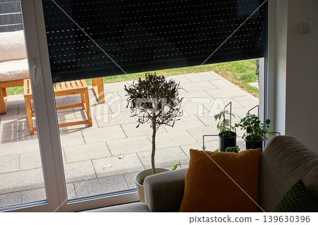 Partially lowered roller shutter over patio glass door Partially lowered roller shutter over patio glass door 139630396