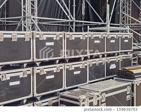 Stacked flight cases and metal stage scaffolding prepared for concert production Stacked flight cases and metal stage scaffolding prepared for concert production 139630703